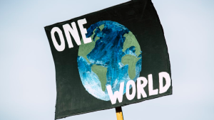 Plakat med bilde av Jorda og teksten "One World", med himmelen som bakgrunn.
